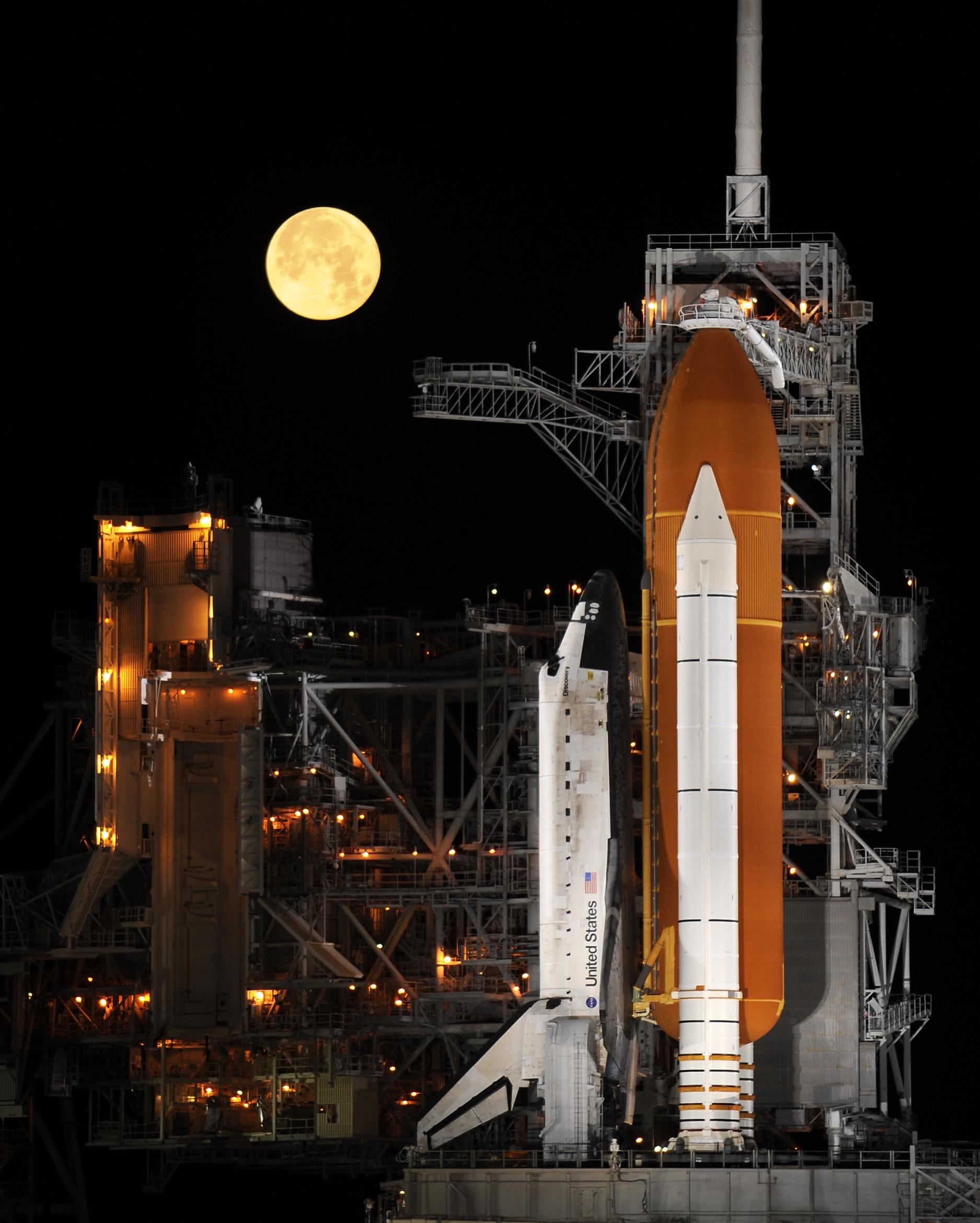 The space shuttle Discovery on Launch Pad 39A under a setting full Moon (2009)