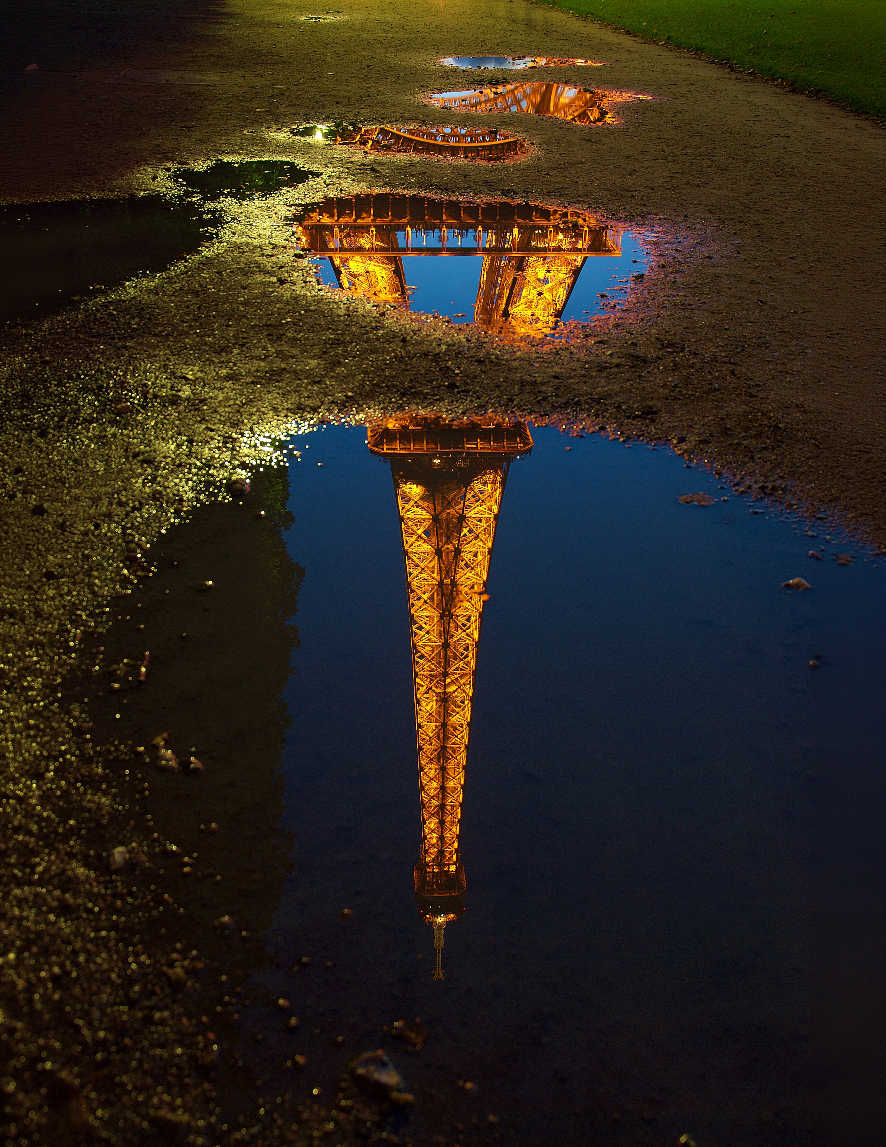 Reflection of the Eiffel tower in a water puddle, Paris, France